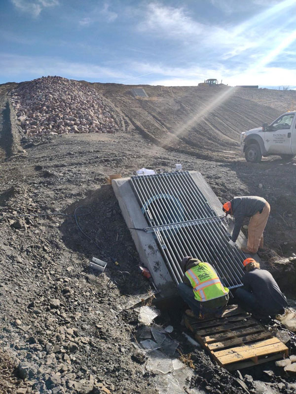 Workers installing outlet grate in South Reservoir