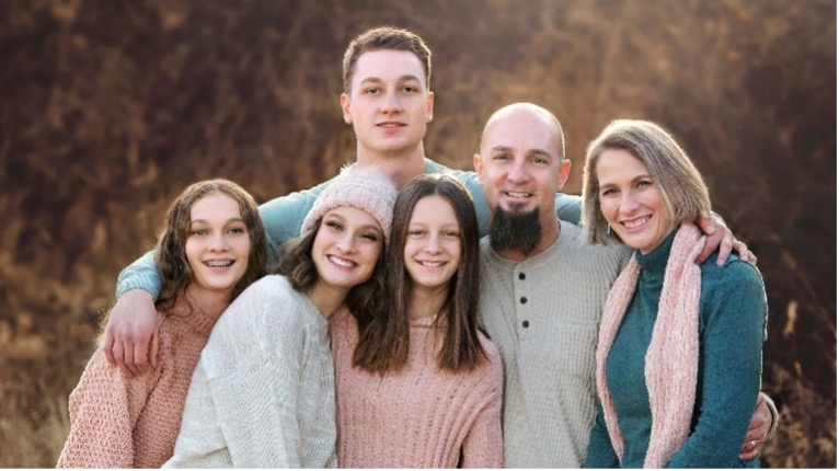 Jason Gross surrounded by his four teenage children and wife.